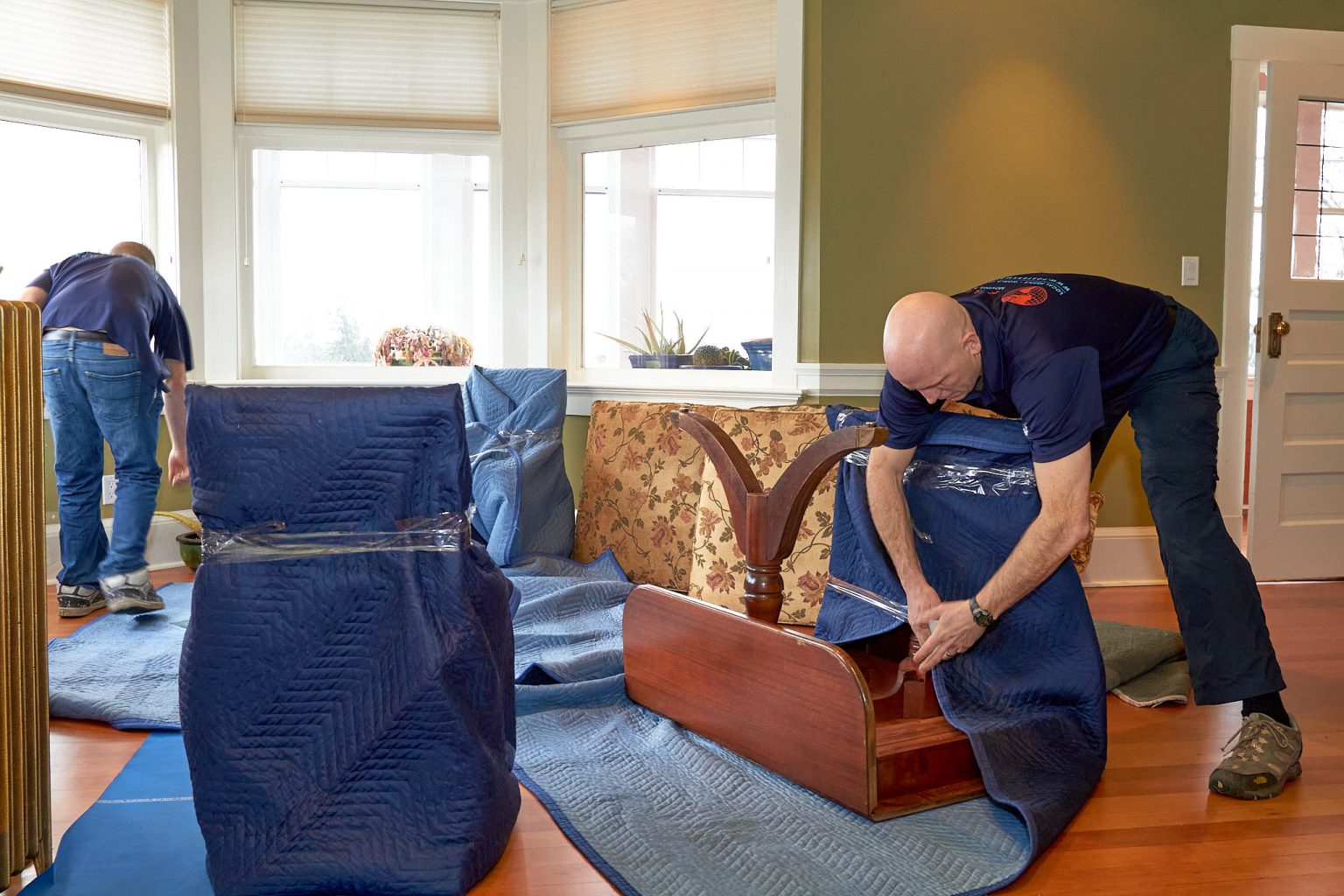 Foster's movers blanket-wrapping furniture before a move